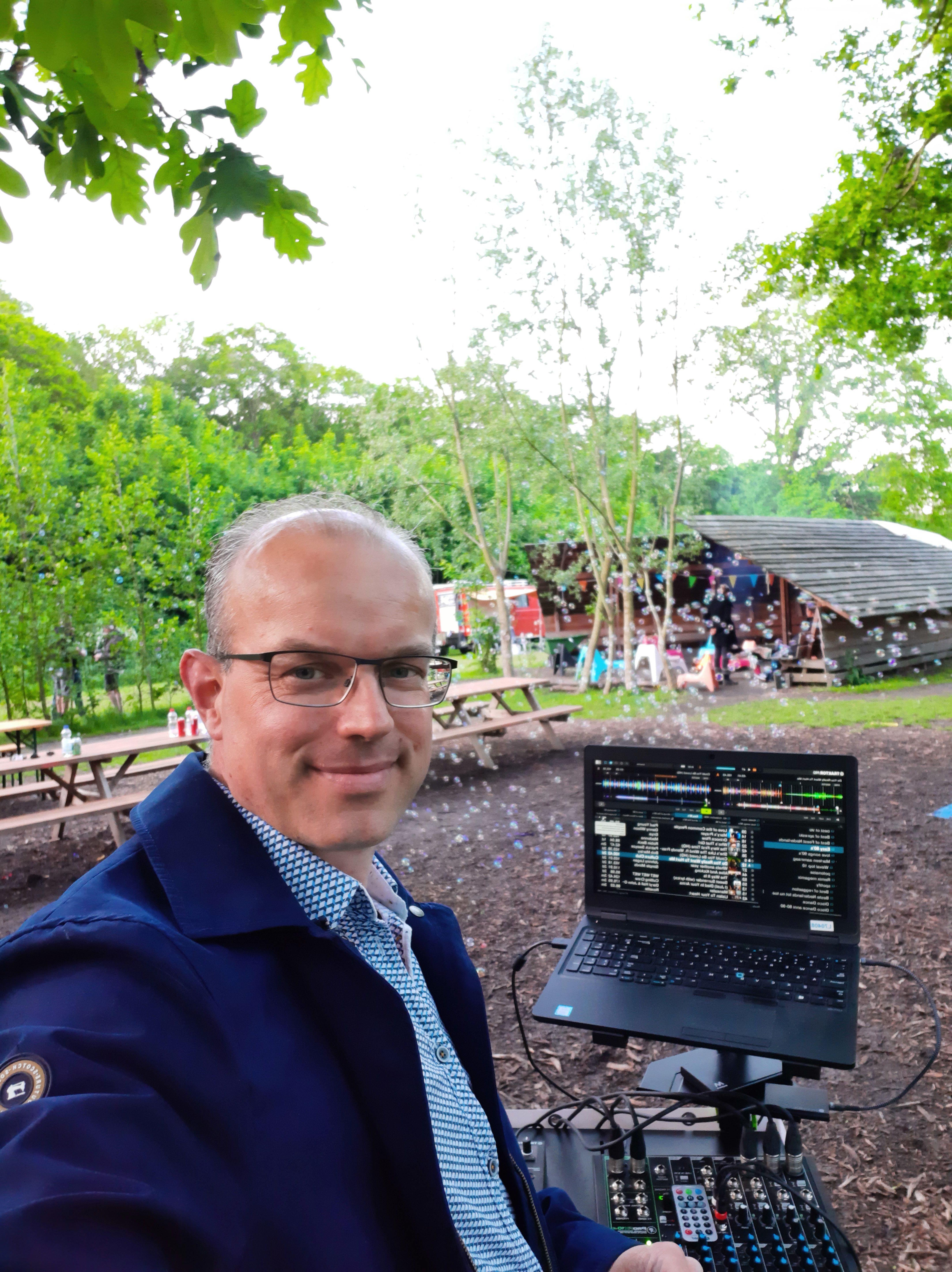 Erik aan het werk in een bosrijke omgeving met laptop en mengpaneel